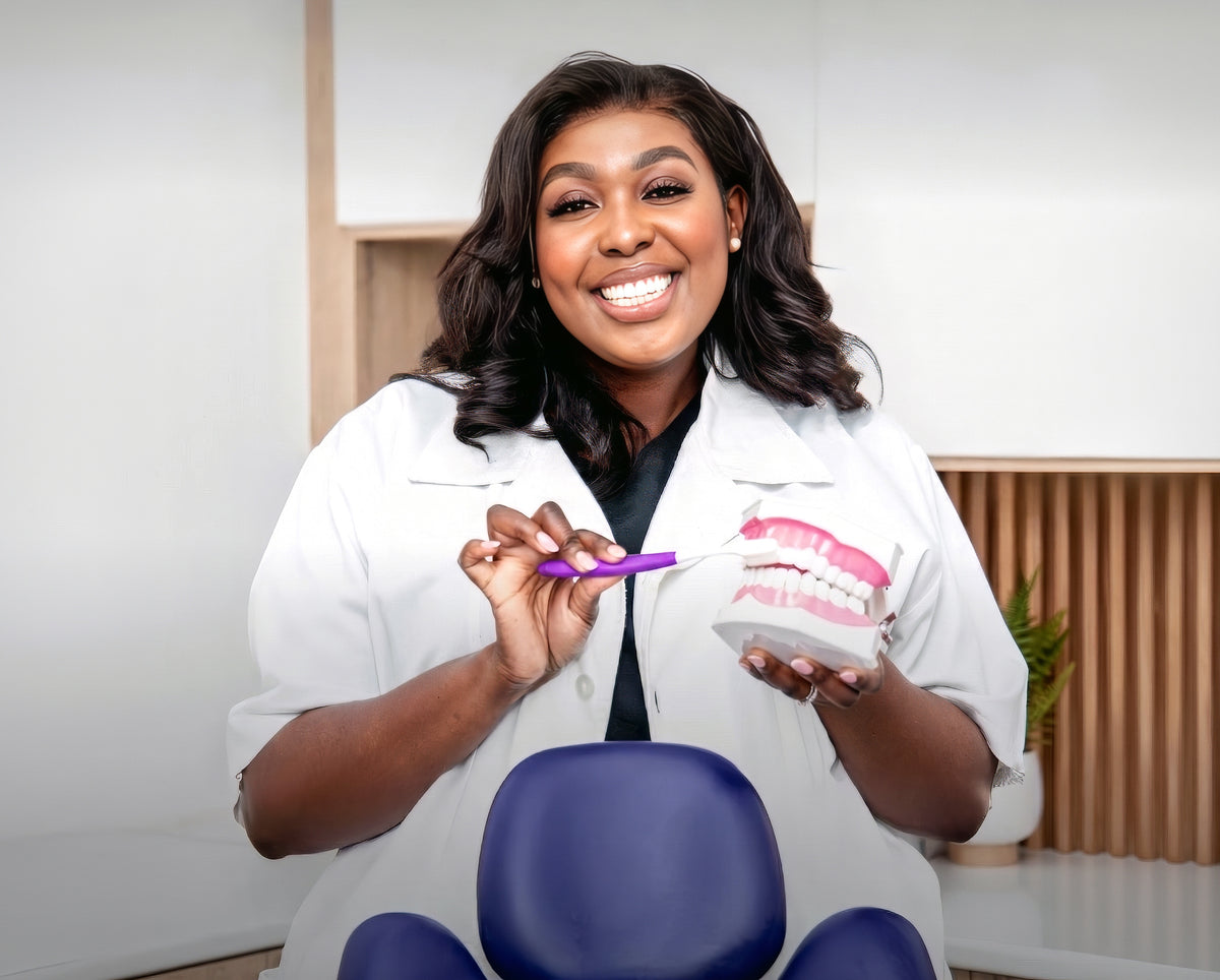 Dr Praise Makhubele-Frederick, dentist and founder of Pravoma Oral Care, holding a toothbrush and dental model in her clinic
